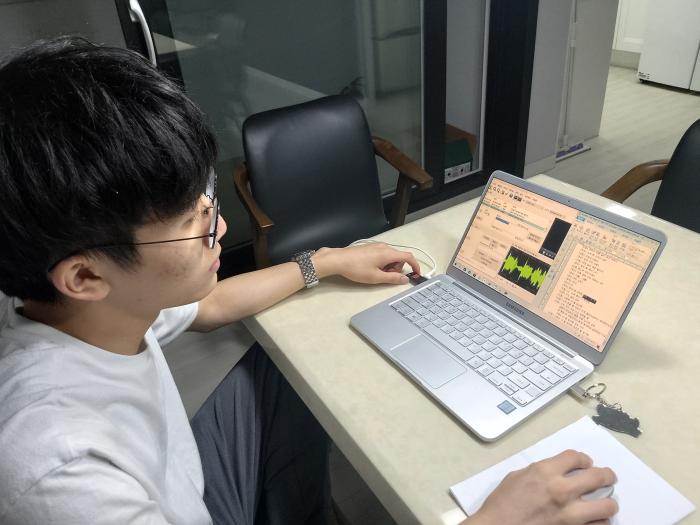 한 소년이 청각 장애인을 위해 한국어 자막을 만들고 있다 